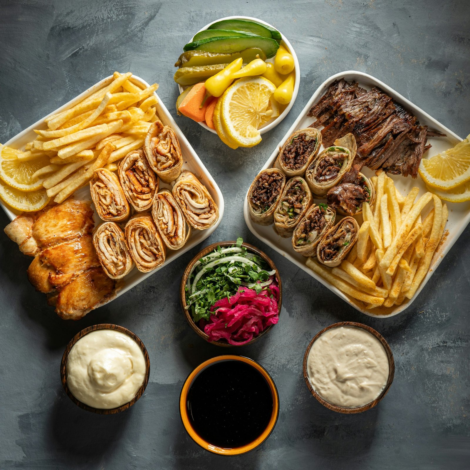 a plate of chicken and lamb shawarma with appetizers