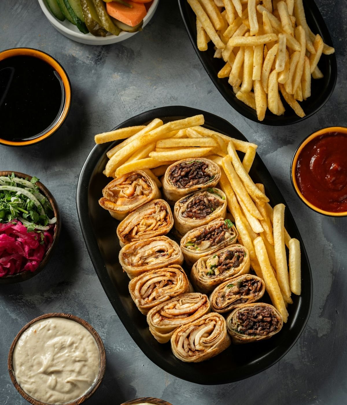 a plate of chicken and lamb shawarma with appetizers